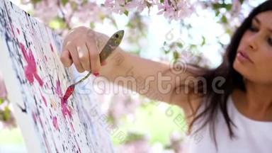 一位穿着白色衣服的美丽女画家的肖像，画家画了一幅盛开的<strong>春天</strong>苹果花的<strong>图画</strong>。
